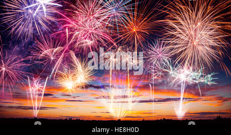 Abstract colored fireworks with free space for text, silhouettes of modern city on background Stock Photo