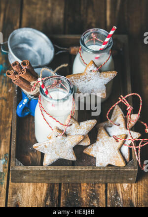 Bottles with milk for Santa and Christmas homemade gingerbread biscuits Stock Photo