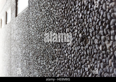 Grey office municipal building with textured, coarse pebbledash surfacing and high windows, fading out to white Stock Photo