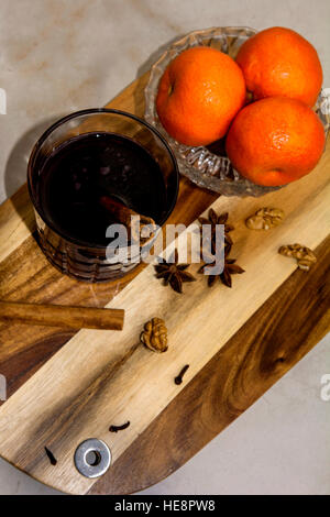 Spiced/ Mulled wine with clementines, cinnamon stick,clove and star anise on a wooden cutting board Stock Photo