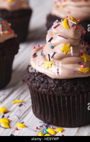 Chocolate cupcakes with light brown cream macro on the table. vertical Stock Photo