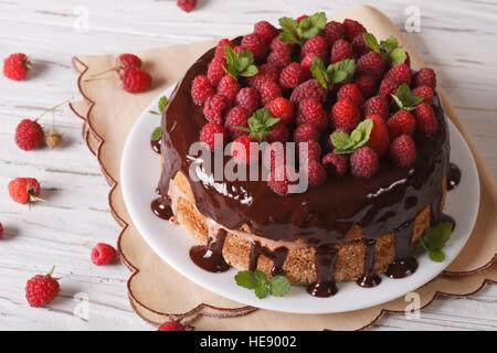 Sponge cake with chocolate and fresh raspberries close-up on the table. horizontal Stock Photo