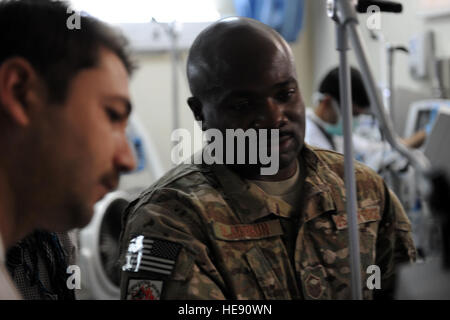 Master Sgt. Oladayo Oladokun, respiratory therapist for the Special Operations Critical Care Evacuation Team, shows an Afghan doctor how to operate a new respiratory machine in the intensive care unit of the Afghan National Army hospital in Herat, Afghanistan, Oct. 10, 2011. Oladokun is deployed from the 1st Special Operations Support Squadron at Hurlburt Field, Fla. He's a native of Bronx, N.Y. Stock Photo