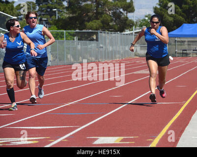 (Ret.) Staff Sgt. Melissa Guzman (left) and (Ret.) Senior Airman Marianne Reilly  cheer on (Ret.) Tech. Sgt. Monica Figueroa during the women's 1500-meter race at the 2014 Air Force Team Trials at Rancho High School, Las Vegas, Nev., April 8, 2014.  During the trials wounded warriors competed in swimming, basketball, volleyball, track and field events, cycling, archery and shooting competitions.  Staff Sgt. Nadine Barclay) Stock Photo