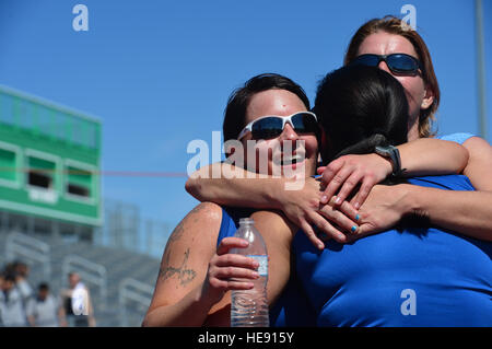 (Ret.) Tech. Sgt. Monica Figueroa is hugged by (Ret.) Staff Sgt. Melissa Guzman (left) and (Ret.) Senior Airman Marianne Reilly after completing the women's 1500-meter race during the 2014 Air Force Team Trials in Rancho High School, Las Vegas, Nev., April 8, 2014.  During the trials wounded warriors competed in swimming, basketball, volleyball, track and field events, cycling, archery and shooting competitions.  Staff Sgt. Nadine Barclay) Stock Photo