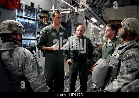 U.S. Air Force Maj. Ben Wood, a C-17 Globemaster III aircraft pilot assigned to the 17th Airlift Squadron, Joint Base Charleston, S.C., conducts a mission briefing with U.S. Army paratroopers from the 2nd Brigade Combat Team, 82nd Airborne Division, on Green Ramp, Pope Army Airfield, N.C., Jan. 27, 2015, during an Emergency Deployment Readiness Exercise. Five hundred paratroopers were airdropped onto Wright Army Airfield, Fort Stewart, Ga., from five C-17 transport aircraft 18 hours after notification. As the nucleus of the nation's Global Response Force, the 82nd Airborne Division provides a  Stock Photo