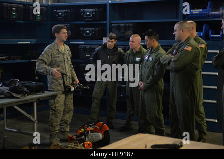 A pararescue jumper from the 103rd Rescue Squadron of the New York Air National Guard's 106th Rescue Wing demonstrates equipment to  aircrew and rescue swimmers from United States Coast Guard's Air Station Elizabeth City, N.C., at Gabreski Air National Guard Base, Westhampton Beach, N.Y., Feb. 5, 2015. The Coast Guardsmen and Air Guard members met  to discuss possible joint training, compare rescue tactics and showcase squadron equipment and training. (U.S. Air National Staff Sergeant Christopher S Muncy / released) Stock Photo