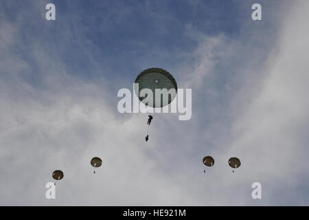 A U.S. Army paratrooper, center, from the 82nd Airborne Division, Ft. Bragg, N.C., descends amongst French Foreign Legion paratroopers from the 2nd Foreign Parachute Regiment (2REP), part of the French Army's 11th Parachute Brigade, during a joint forceable entry airdrop at Paolomagno Drop Zone, near Solenzara Air Base, Corsica, France on May 29, 2014 in support of Allied Forge 2014. This exercise, led by the 82nd Airborne Division in conjunction with the 152nd and 165th Air National Guard Airlift Wings, is the first-ever interoperability exercise designed to enhance bilateral capabilities bet Stock Photo
