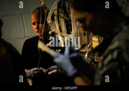 U.S. Navy Hospital Corpsman Third Class Ashley Smith of Cashmere, Wash., Forward Surgical Team Farah operating room technician, left, provides medical treatment to an Afghan National Army soldier at Forward Operating Base Farah, Afghanistan, Aug. 13. Two ANA soldiers were medically treated by coalition forces after sustaining wounds from an Improvised Explosive Device explosion which detonated near the village of Masaw in Pusht Rod district, Farah province. One ANA soldier succumbed to injuries, while the other remains in critical condition and is currently undergoing surgery conducted by the  Stock Photo