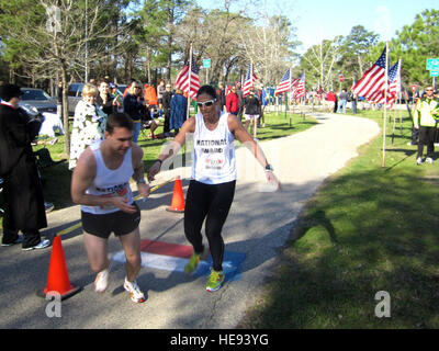 Sgt. Luke Mostoller, Arizona Army National Guard, receives the baton from teammate Maj. Rebecca Hoffman, South Dakota Army National Guard, for his last leg of 5.18 miles to downtown Houston, Texas March 6.  Tech. Sgt. Tyrell Heaton, DC ANG) Stock Photo