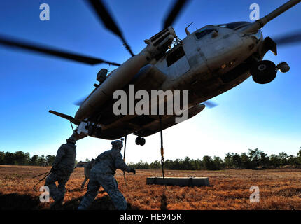 U.S. Airmen assigned to the 621st Contingency Response Wing clear the area after attaching cargo to a Marine Corps CH-53E Super Stallion helicopter assigned to Heavy Helicopter Squadron 772 during sling load training at Joint Base McGuire-Dix-Lakehurst, N.J., Jan. 9, 2014. The training was designed to prepare air and ground units for moving suppplies into areas fixed-wing aircraft cannot reach.  Tech. Sgt. Edward Gyokeres, U.S. Air Force Stock Photo