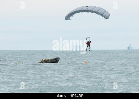 An Air Force Reserve pararescueman descends into the Atlantic Ocean from an Air Force C-17 Globemaster III in an effort to recover a NASA astronaut as part of an exercise Jan. 14 off the shore of Cape Canaveral Air Force Station, Fla. The 45th Operations Group Detachment 3 joined NASA's Commercial Crew Program and Air Force pararescuemen, combat rescue officers and survival, evasion, resistance and escape specialists to simulate to practice recovering astronauts quickly and safely in the event they would need to abort their spacecraft. The small Air Force detachment has served as the liaison b Stock Photo