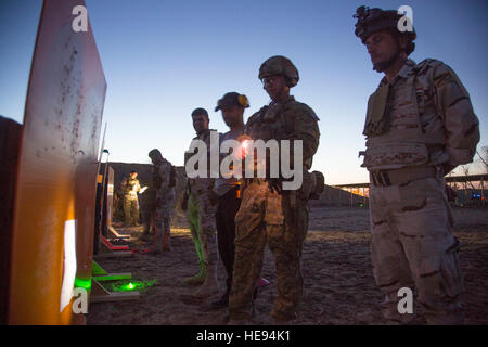 An Australian soldier, center, assigned to Task Group Taji, and an Iraqi soldier, right, with the Security Battalion, Nineveh Operations Command, review a 25-meter target during a night range at Camp Taji, Iraq, April 3, 2016. Task Group Taji conducted a night range to gauge the Iraqi soldiers night firing capabilities. Training at the building partner capacity sites is an integral part of Combined Joint Task Force – Operation Inherent Resolve’s multinational effort to train Iraqi security force personnel to defeat the Islamic State of Iraq and the Levant. (U.S. Army  Spc. William Lockwood Stock Photo