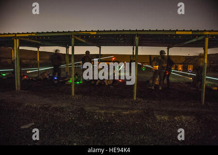 Australian soldiers, assigned to Task Group Taji, observe Iraqi soldiers with the Security Battalion, Nineveh Operations Command, firing their AK-47 rifles during night range training at Camp Taji, Iraq, April 3, 2016. Task Group Taji conducted night range training to gauge the Iraqi soldiers night firing capabilities. Training at the building partner capacity sites is an integral part of Combined Joint Task Force – Operation Inherent Resolve’s multinational effort to train Iraqi security force personnel to defeat the Islamic State of Iraq and the Levant. (U.S. Army  Spc. William Lockwood Stock Photo