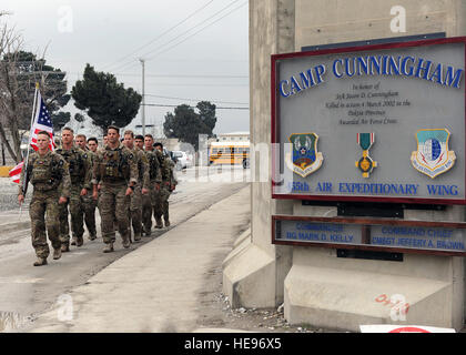 A multiservice formation of special operators marches with a U.S. flag bearing the names of seven special operators who were killed March 4, 2002 during Operation Anaconda: U.S. Air Force Senior Airman Jason Cunningham, U.S. Army Cpl. Matthew Commons, U.S. Army Spc. Marc Anderson, U.S. Army Sgt. Phillip Svitak, U.S. Army Sgt. Bradley Crose, U.S. Navy Petty Officer 1st Class Neil Roberts and U.S. Air Force Tech. Sgt. John Chapman, March 4, 2015 at Bagram Air Field, Afghanistan. Service members from all branches conducted a 24-hour vigil run and a retreat ceremony to honor the 13th anniversary o Stock Photo