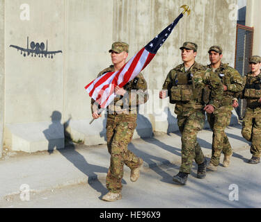 A multiservice formation of special operators runs with a U.S. flag bearing the names of seven special operators who were killed March 4, 2002 during Operation Anaconda: U.S. Air Force Senior Airman Jason Cunningham, U.S. Army Cpl. Matthew Commons, U.S. Army Spc. Marc Anderson, U.S. Army Sgt. Phillip Svitak, U.S. Army Sgt. Bradley Crose, U.S. Navy Petty Officer 1st Class Neil Roberts and U.S. Air Force Tech. Sgt. John Chapman, March 3, 2015 at Bagram Air Field, Afghanistan. Service members from all branches conducted a 24-hour vigil run and a retreat ceremony to honor the 13th anniversary of t Stock Photo