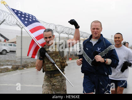 U.S. Air Force Brig. Gen. Mark Kelly, 455th Air Expeditionary Wing commander, and U.S. Air Force Chief Master Sgt. Ramon 'CZ' Colon-Lopez, Air Force Central Command command chief, run with a flag bearing the names of seven special operators who were killed March 4, 2002 during Operation Anaconda: U.S. Air Force Senior Airman Jason Cunningham, U.S. Army Cpl. Matthew Commons, U.S. Army Spc. Marc Anderson, U.S. Army Sgt. Phillip Svitak, U.S. Army Sgt. Bradley Crose, U.S. Navy Petty Officer 1st Class Neil Roberts and U.S. Air Force Tech. Sgt. John Chapman, March 4, 2015 at Bagram Air Field, Afghan Stock Photo