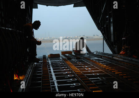 Airman 1st Class Nicholas Ellwood and Staff Sgt. Ronnie James, 777th Expeditionary Airlift Squadron loadmasters, wait for cargo and passengers to be loaded onto a C-130 Hercules during a combat mission in Southwest Asia, May 7. The 777 EAS personnel estimate they have prevented approximately 10,000 convoy vehicles and about 27,000 servicemembers from traveling along improvised explosive device laden Iraqi roads since the squadron stood up in January 2006. This was accomplished by providing air transport by a C-130, the 'work horse' of the Air Force fleet. Ellwood and James are deployed from Li Stock Photo