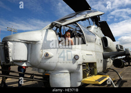 A visitor tours an AH-1Z Super Cobra, Marine Light Attack Helicopter Squadron 469, Futenma, Okinawa, at Air Power Day, an Exercise Balikatan 2015 outreach event at Clark Air Base, Philippines, April 25. The event gave roughly 1,000 visitors the chance to visit more than 15 different aircraft from the Philippine and U.S. Armed Forces and speak with crew members to better understand how each aircraft contributes to the bilateral mission of Balikatan.  Staff Sgt. Maeson L. Elleman) Stock Photo