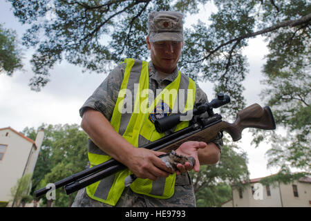 Maj. Jason Powell, 12th Flying Training Wing chief of flight safety, gathers a white-winged dove after striking it with the air pellet rifle at Joint Base San Antonio-Randolph July 13, 2016. The Bird/Wildlife Aircraft Strike Hazard program reduces the threat that the nearly 400 different species of birds pose each year as they travel along the Central Americas Flyway. Stock Photo