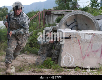 U.S. Army Sgt. Eric Gainan (center), 302nd Quartermaster Company, U.S. Army Reserve (USAR), aims down range and provides cover for Spc. Eleu Wilson, 777th Aviation Support Battalion, U.S. Army National Guard, during a movement under direct fire exercise as part of the 2015 Hawaii Army National Guard and Reserve Best Warrior Competition March 8, 2015, at Marine Corps Training Area Bellows, Hawaii. Competitors included eight Soldiers from the U.S. Army National Guard and thirteen reserve Soldiers assigned to units throughout the Pacific Region.  Staff Sgt. Christopher Hubenthal) Stock Photo