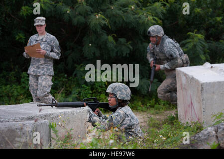 U.S. Army Pfc. Desiree Dacoco (center foreground), 322nd Civil Affairs Brigade, U.S. Army Reserve (USAR), aims down range toward a simulated enemy as a U.S. Army Soldier bounds forward to cover during a movement under direct fire exercise as part of the 2015 Hawaii Army National Guard and Reserve Best Warrior Competition March 8, 2015, at Marine Corps Training Area Bellows, Hawaii. Competitors included eight Soldiers from the U.S. Army National Guard and 13 USAR Soldiers assigned to units throughout the Pacific Region.  Staff Sgt. Christopher Hubenthal) Stock Photo