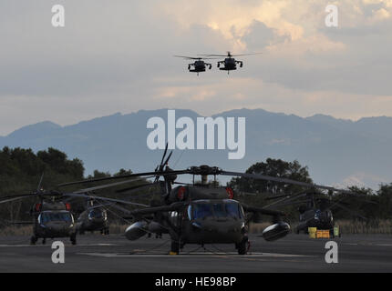 A pair of UH-60 Black Hawks assigned to Joint Task Force-Bravo's 1-228th Aviation Regiment come in for a landing at Soto Cano Air Base, Honduras, Feb. 12, 2014. The two aircraft were returning after transporting a delegation of several U.S. and Honduran distinguished visitors, including U.S. Marine Corps Gen. John F. Kelly, commander, U.S. Southern Command, and U.S. Ambassador to Honduras Lisa Kubiske, to visits to multiple Honduran military installations throughout the country.  Capt. Zach Anderson) Stock Photo