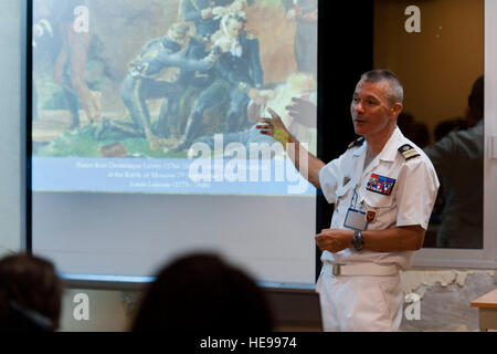 Colonel Michel Ruttiman, French Defense Health Service (Service de santé des armées), discusses the painting,  'Baron Jean Dominique Larrey Tending the Wounded at the Battle of Moscow,' by Louis Lejeune. U.S. Navy Capt. Michael Matteucci, Combined Joint Task Force-Horn of Africa (CJTF-HOA) Expeditionary Medical Facility (EMF) senior medical officer, demonstrated the separate levels of triage urgency using the painting in a presentation earlier in the day during a disaster medicine seminar May 10, 2014, at the Bouffard French Military Hospital (Le Groupement médico-chirurgical Bouffard).  Staff Stock Photo