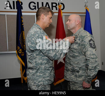 Maj. Gen. Daniel Hokanson, adjutant general Oregon, awards the Bronze Star Medal to Senior Master Sgt. Brian Wade, of the 142nd Fighter Wing Explosive Ordinance Disposal unit, during a ceremony held at the Portland Air National Guard Base, in Portland, Ore., Nov. 3, 2013. As part of the ceremony both Wade and Maj. Casey Dierickx, 142nd Fighter Wing executive officer, were awarded the Bronze Star for their service during Operation Enduring Freedom. ( Tech. Sgt. John Hughel, 142nd Fighter Wing Public Affairs Stock Photo