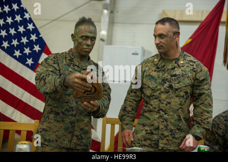 U.S. Marine Corps Staff Sgt. Micheal J. Porter, infantry unit leader, (left) with Alpha Company, Black Sea Rotational Force, presents a placard to Major Chris M. Reynolds, battalion executive officer during a mess night aboard Mihail Kogalniceanu Air Base, Romania, April 6, 2016. No matter where Marines are in the world, they find opportunities to gather together to espouse unit cohesion and esprit de corps.  Lance Cpl. Kyle A. Kauffman, 2D MARDIV COMCAM/ Released) Stock Photo