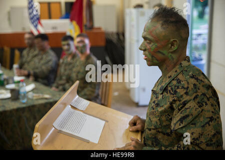 U.S. Marine Corps Staff Sgt. Micheal J. Porter, infantry unit leader and president of the mess with Alpha Company, Black Sea Rotational Force, reads a message about the mess night aboard Mihail Kogalniceanu Air Base, Romania, April 6, 2016. No matter where Marines are in the world, they find opportunities to gather together to espouse unit cohesion and esprit de corps.  Lance Cpl. Kyle A. Kauffman, 2D MARDIV COMCAM/ Released) Stock Photo