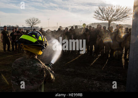 U.S. Army firefighters with the Mihail Kognaliceanu Air Base Fire Department use a water hose to wash mud off U.S. Marines with Black Sea Rotational Force after participate in a tournament-style grappling exercise aboard Mihail Kognaliceanu Air Base, Romania, Jan. 29, 2016. Marines with 1st Battalion, 8th Marine Regiment deployed to Romania to provide U.S. European Command the capability to enable NATO allies and partner nations in Eastern Europe.  Cpl. Tyler A. Andersen) Stock Photo