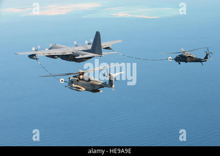 DJIBOUTI – A U.S. Marine Corps CH-53 Super Stallion from the Heavy Marine Helicopter 464 Detachment A and a U.S. Air Force HH-60 Pave Hawk from the 303rd ExpediRonary Rescue Squadron refuel from a U.S. Air Force MC-130 from the 81st ExpediRonary Rescue Squadron during a familiarizaRon flight, Jan. 29, 2013. The HMH-464 relinquished the Marines’ 10-year personnel recovery mission to the newly formed 303rd EQRS. The squadron will conRnue to ensure CJTF-HOA provides responsive medical evacuaRon support and personnel recovery for all U.S. personnel in East Africa.  Staff Sgt. Jonathan Young) Stock Photo