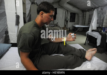 Marine Lance Cpl. Chris Spadaccini, a squad-automatic-weapons gunner assigned to 1/6 Marine Expeditionary Force, Bravo Company, 3rd Platoon, holds the bullet that was removed from his shoulder and tells the story at the 451st Expeditionary Aeromedical Evacuation Squadron, Detachment 1 Contingency Aeromedical Staging Facility, April 13, at Camp Bastion, Afghanistan. Stock Photo