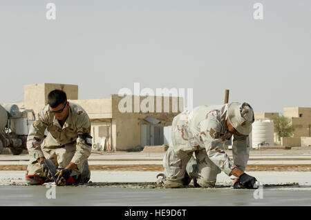 Staff Sgt. James Baker and Tech. Sgt Rudy Moreno edge and float freshly poured cement while their team builds a drill pad at Camp Mittica, Iraq, on June 11, 2007.  Both are 'Dirt Boy's' assigned to the 407th Expeditionary Civil Engineer Squadron (ECES), Ali Air Base, Iraq, and are on the Iraqi base building a 220' X 200' cement drill pad that will be used by the Iraqi army to train their enlisted soldiers.        Master Sgt. Robert W. Valenca ( Released) Stock Photo