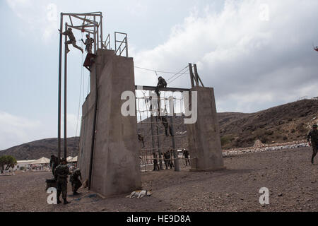 U.S. military personnel assigned to Combined Joint Task Force-Horn of Africa (CJTF-HOA), along with French Foreign Legion soldiers, negotiate a rope obstacle course as part of a desert commando course in Arta, Djibouti, March 13, 2016. Through unified action with U.S. and international partners in East Africa, CJTF-HOA conducts security force assistance, executes military engagement, provides force protection, and provides military support to regional counter-violent extremist organization operations in order to support aligned regional efforts, ensure regional access and freedom of movement,  Stock Photo