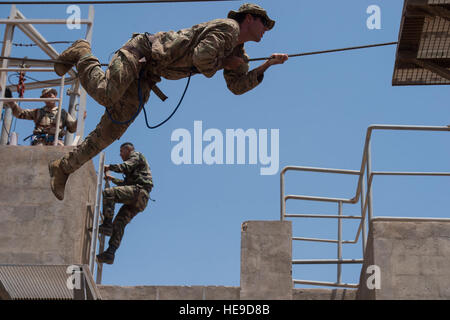 A U.S. Soldier assigned to Combined Joint Task Force-Horn of Africa (CJTF-HOA), along with French Foreign Legion soldiers, negotiates a rope obstacle course as part of a desert commando course in Arta, Djibouti, March 13, 2016. Through unified action with U.S. and international partners in East Africa, CJTF-HOA conducts security force assistance, executes military engagement, provides force protection, and provides military support to regional counter-violent extremist organization operations in order to support aligned regional efforts, ensure regional access and freedom of movement, and prot Stock Photo