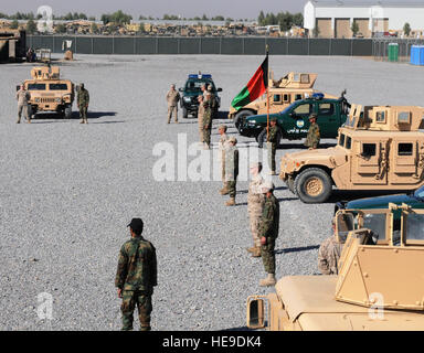 U.S. Marine advisers and Afghan National Army soldiers stand in front of uip-armored Humvees and police pickups prior to the transfer of authority ceremony at the Regional Military Training Center, Nov. 12, in Kandahar, Afghanistan. The coalition training advisory team transferred the up-armored Humvee course to full ANA control. Stock Photo