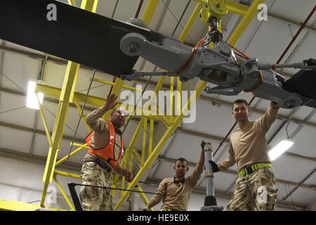 Maintainers from the Colombian air force use a hoist to move the main rotor blade for the Colombian air force Bell 212 helicopter in place on the aircraft in preparation for Exercise ANGEL THUNDER at Davis-Monthan AFB, Ariz., April 29, 2014. Exercise ANGEL THUNDER is an annual exercise that supports the DOD's training requirements for personnel recovery, but also fosters relationships between joint, interagency, and coalition partners. This year's exercise will occur from May 4-17 throughout Arizona and off the coast of California. The Colombian military is one of the largest international par Stock Photo