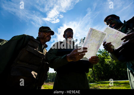 U.S. Air Force pilots from the 14th and 17th Airlift Squadrons read a tactical map for terrain navigation during Combat Survival Training at Joint Base Charleston - Weapons Station, S.C., June 21, 2012. The training is designed for aircrews and other personnel to implement survival techniques to evade enemy forces and to signal friendly forces. Stock Photo