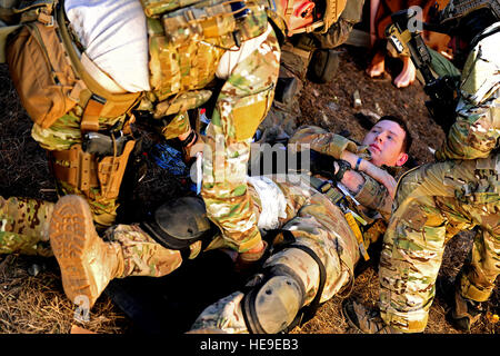 U.S. Army Rangers, 1st Battalion, 75th Ranger Regiment, Charlie Company, simulate medically treating a ranger who was shot in the leg while participating in a Combined Arms Live Fire Exercise (CALFX) near Ft. Stewart, Ga., January 12, 2012. The exercise is conducted in order to evaluate and train members on de-escalation of force, reactions to enemy contact, and other objectives that prepare them for forward operating.   Airman 1st Class Matthew J. Bruch Stock Photo