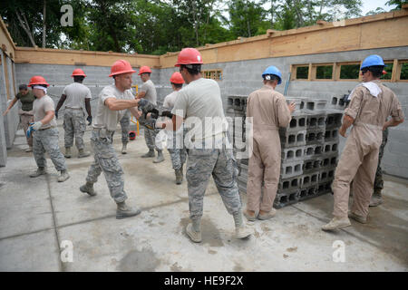 Airmen and Marines move bricks to construct interior walls of a two-room schoolhouse at Gabriela Mistral school site in Ocotes Alto, Honduras, June 24, 2015, as part of New Horizons Honduras 2015 humanitarian and training exercise. Stock Photo
