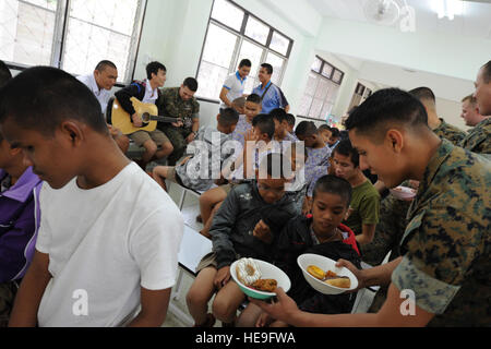 U.S. sailors and Marines assigned to the Marine All-Weather Fighter Attack Squadron 533, Marine Corps Air Station Iwakuni, Japan, pass out lunch to the students of the Korat Branch of the School for the Blind Education Service Center in Korat, Thailand during a break from Cope Tiger 2011,  an annual, multilateral, joint field training exercise currently being conducted at Korat and Udon Thani Royal Thai Air Bases March 14-25. The service members visited the school as one of the many community relation events that take place during the annual exercise. Participants of Cope Tiger include the U.S Stock Photo