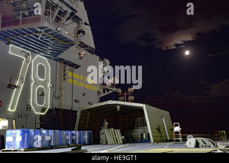 The Pre-Commissioning Unit Gerald R. Ford (CVN 78) aircraft carrier under construction at Huntington Ingalls Industries Newport News Shipbuilding, with illuminated superstructure and flight deck, is shown at night. Stock Photo