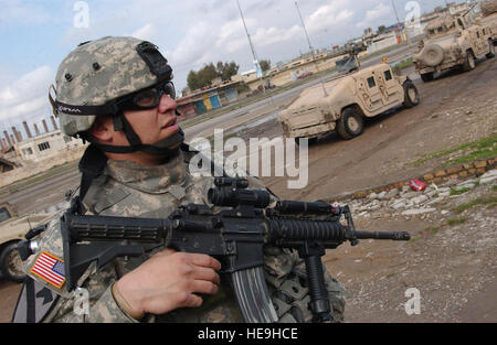 U.S. Army Staff Sgt. Jason Elemen, 2nd Battalion, 7th Cavalry Regiment, 4th Brigade Combat Team, 1st Cavalry Division, from Fort Bliss, Texas, provides security outside a factory suspected of housing bomb making materials used in recent IED attacks on U.S forces Feb. 16, 2007 in support Operation Iraqi Freedom.( Senior Airman Vanessa Valentine)(Released) Stock Photo