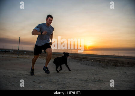 U.S Air Force Staff Sgt. Jesse Galvan, 386th Expeditionary Security Forces Squadron military working dog handler, runs in the early morning with his dog, Ritz, July 19, 2014 at an undisclosed location in Southwest Asia. Galvan has been partnered with Ritz for two and a half years and deployed twice with her. The Dallas-Ft. Worth native deployed here from Tinker Air Force Base, Oklahoma in support of Operation Enduring Freedom.  Staff Sgt. Jeremy Bowcock) Stock Photo