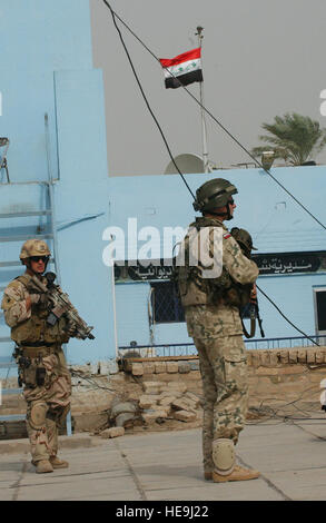 A Polish army soldier, right, and a U.S. Navy Explosive Ordnance Disposal team member from Camp Echo, Iraq, provide security for other team members as they conduct official business at the Iraqi police headquarters in Ad Diwaniyah, Iraq.  Tech. Sgt. Dawn M. Price) (Released) Stock Photo