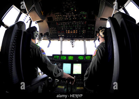 U.S. Air Force Lt. Col. Greg Ervin, 115th Airlift Squadron, California Air National Guard, and Capt. Patrick McBride prepare to drop fire retardant over a wildfire while flying aboard a Modular Airborne Firefighting System equipped C-130J Hercules over Scurry County, Texas, April 26. MAFFS is capable of dispensing 3,000 gallons of water or fire retardant in under 5 seconds. Wildfires have spread across various parts of Texas and have burned more than 1,000 square miles of land. Stock Photo