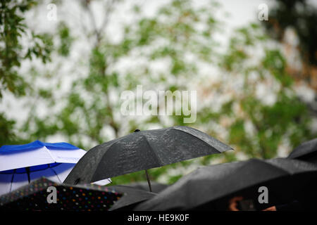 Umbrellas come out as it begins to rain at the farewell tribute for Joint Chiefs of Staff Vice Chairman Gen. James E. Cartwright at the Marine Corps Barracks, Washington, D.C., Aug. 3, 2011.  Tech. Sgt. Jacob N. Bailey, U.S. Air Force Stock Photo