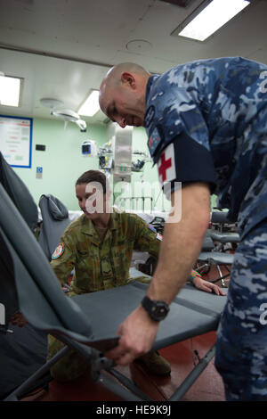 PACIFIC OCEAN - (June 5, 2015) Royal Australian Air Force Leading Aircraft Woman Hannah Sunasky, a dental technician from Adelaide, Australia, and Flight Lt. Luke Pitty, a dentist from Townsville, Australia, set up a dental examination chair aboard the Military Sealift Command hospital ship USNS Mercy (T-AH 19) during Pacific Partnership 2015.  The dental chairs are part of a mobile dental lab, which will enable medical personnel to treat children near the Veiuto Primary School during a community health engagement. Pacific Partnership is in its tenth iteration and is the largest annual multila Stock Photo